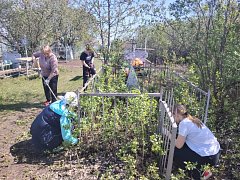 Школьники и учителя убрали территорию у памятного креста